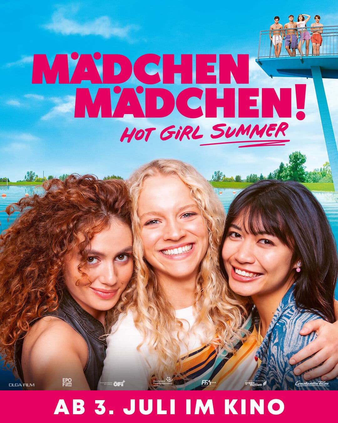 Filmplakat für "Mädchen Mädchen! Hot Girl Summer" zeigt drei fröhlich lachende junge Frauen in Nahaufnahme vor einem sommerlichen Freibad-Hintergrund. Im oberen Bereich steht der Filmtitel in kräftigem Pink, darunter der Schriftzug "Hot Girl Summer" in verspielter Handschrift. Im Hintergrund sieht man auf einem Sprungturm weitere Mädchen. Am unteren Rand steht in Weiß auf pinkem Balken: "Ab 3. Juli im Kino".